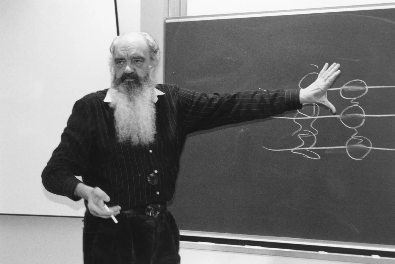 Stafford Beer en St. Gallen, 1990 Stafford Beer, con barba larga y blanca, señala un diagrama de círculos dibujado con gis en un pizarrón