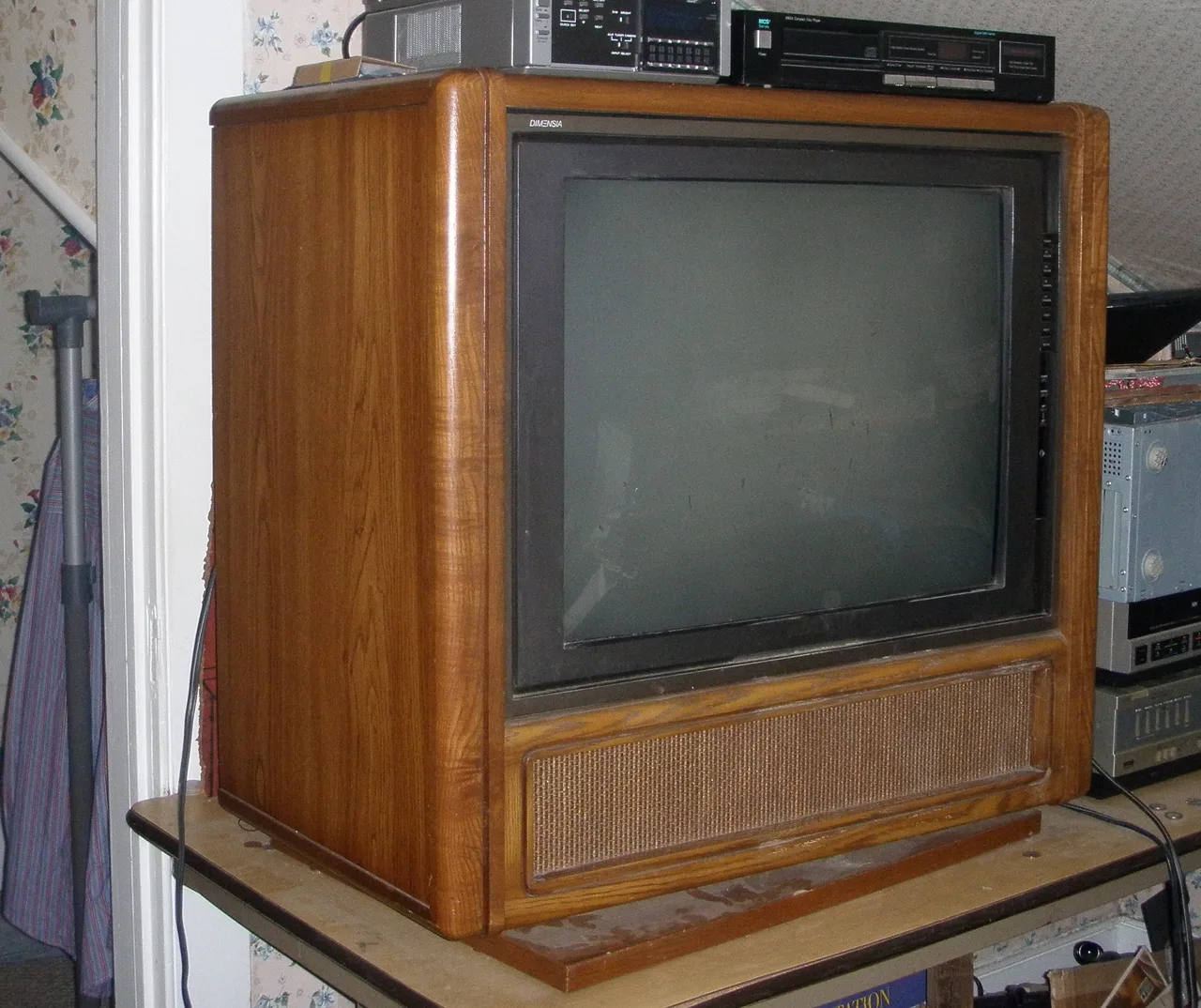 Televisor RCA Dimensia de consola con mueble de madera, con un reproductor de discos compactos encima
